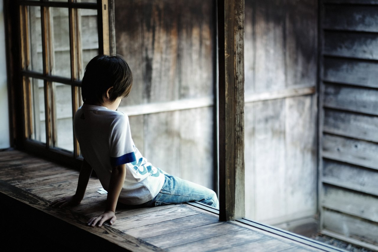 寂しそうにしている子供の後ろ姿