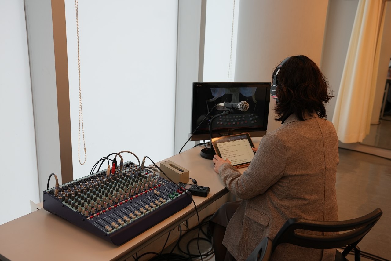 音声ガイド 楽屋で舞台の様子をモニターで確認しながら、リアルタイムでガイドを行っている。